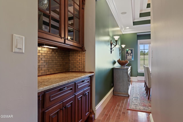 bar with backsplash, baseboards, ornamental molding, recessed lighting, and wood finished floors