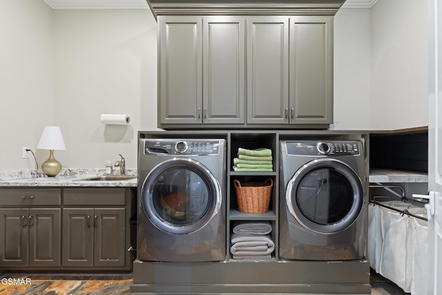 laundry area with cabinet space, independent washer and dryer, and a sink