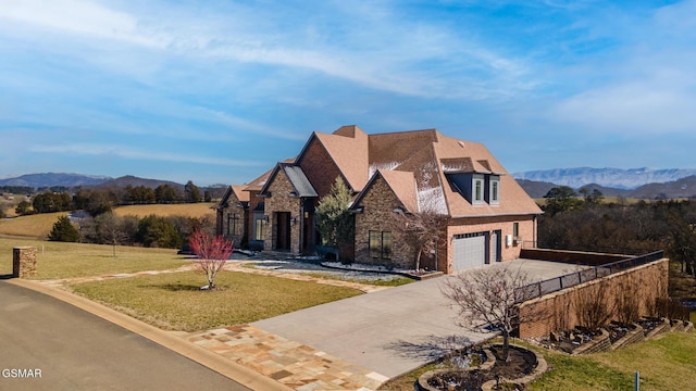 view of front of property featuring a front lawn, fence, a mountain view, and driveway