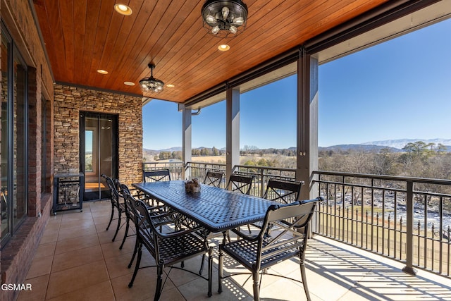 exterior space with a balcony, outdoor dining area, and a mountain view