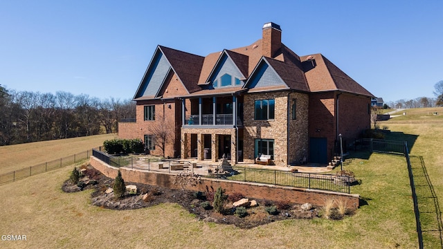 back of property with brick siding, fence private yard, a chimney, a yard, and a patio