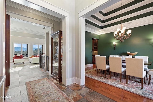 dining room featuring baseboards, crown molding, and an inviting chandelier