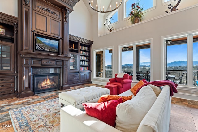 living area featuring a glass covered fireplace, a mountain view, and an inviting chandelier