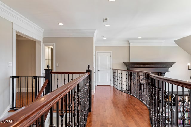 hall with recessed lighting, an upstairs landing, wood-type flooring, and ornamental molding