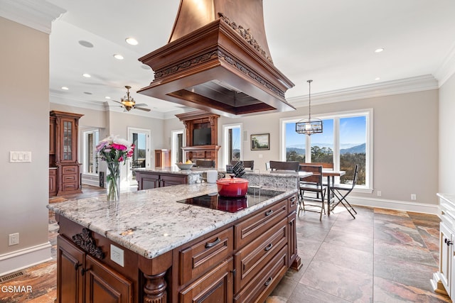 kitchen featuring a center island, a large fireplace, black electric cooktop, and ornamental molding