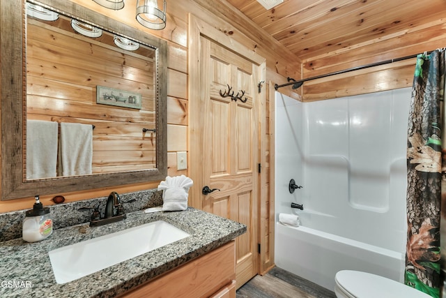 full bathroom with toilet, vanity, wooden walls, wood ceiling, and shower / bath combo with shower curtain