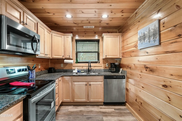 kitchen with sink, wooden walls, stainless steel appliances, and wooden ceiling