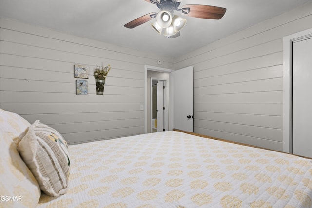 bedroom featuring ceiling fan and wood walls