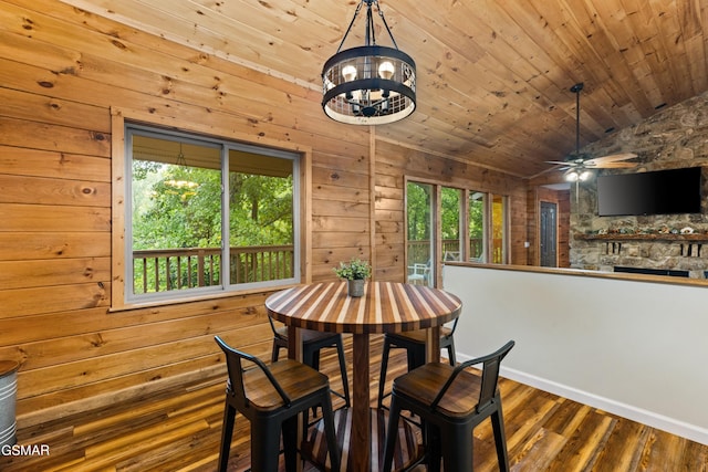 dining area with ceiling fan, wooden walls, dark wood-type flooring, wooden ceiling, and lofted ceiling