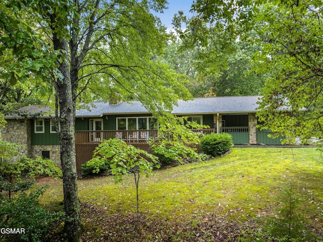 ranch-style home with a deck and a front yard