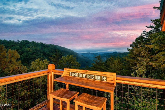 deck with a forest view and a mountain view