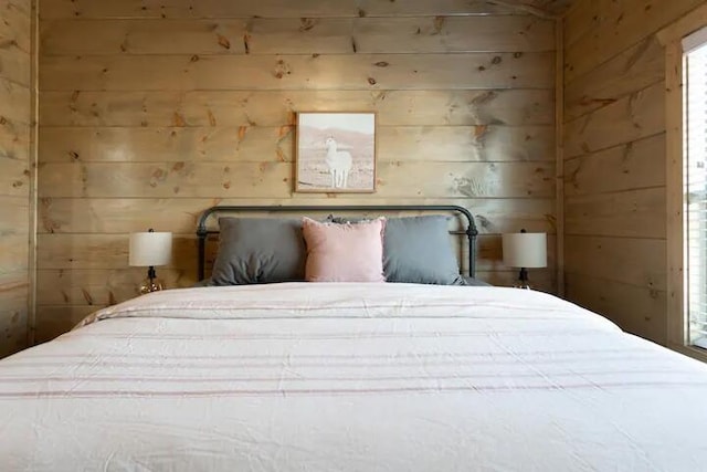 bedroom featuring wooden walls