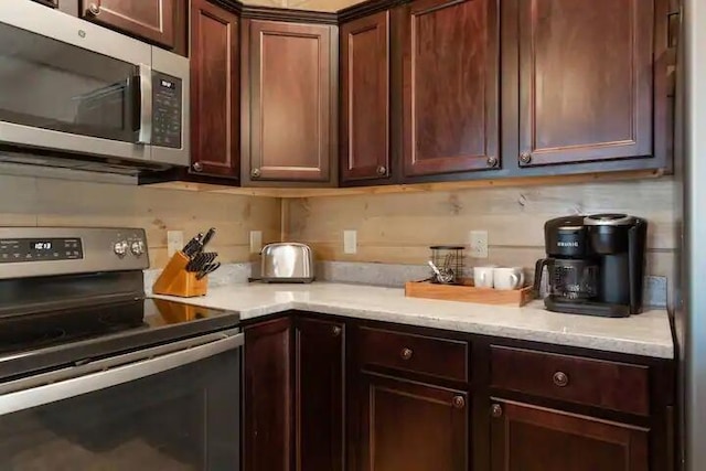 kitchen featuring tasteful backsplash, light stone counters, and stainless steel appliances