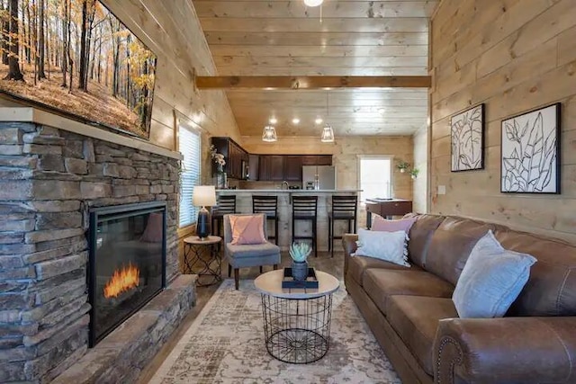 living room featuring wood ceiling, a fireplace, and lofted ceiling with beams