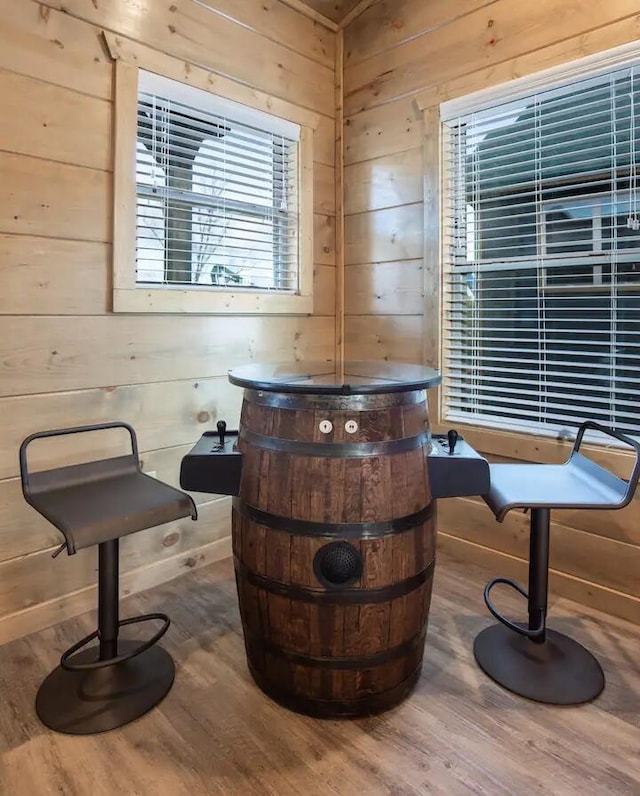 bar with wood-type flooring and wooden walls