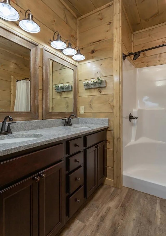 bathroom featuring wood walls, hardwood / wood-style floors, vanity, and a shower with shower curtain