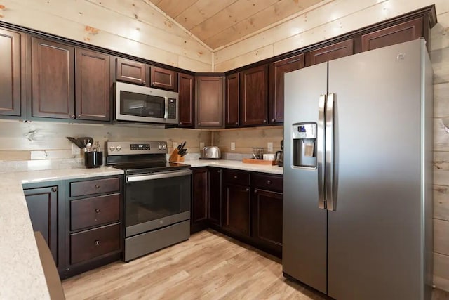 kitchen with light hardwood / wood-style flooring, dark brown cabinetry, stainless steel appliances, and vaulted ceiling