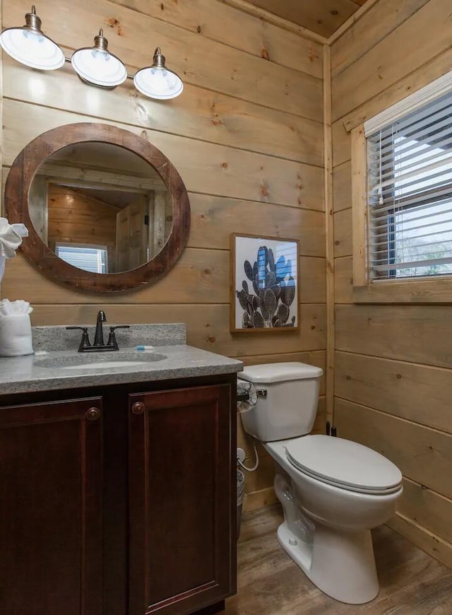 bathroom featuring wood walls, wood-type flooring, and toilet