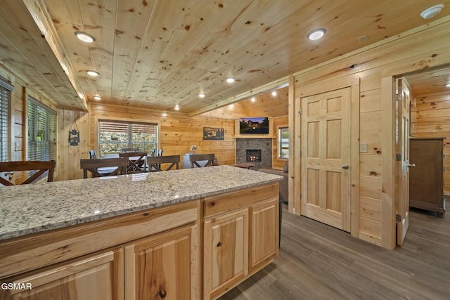 1515 Rainbow Ridge Way, Sevierville, TN 37862 - kitchen featuring wood walls, wood ceiling, dark wood-style flooring, a stone fireplace, and light stone counters
