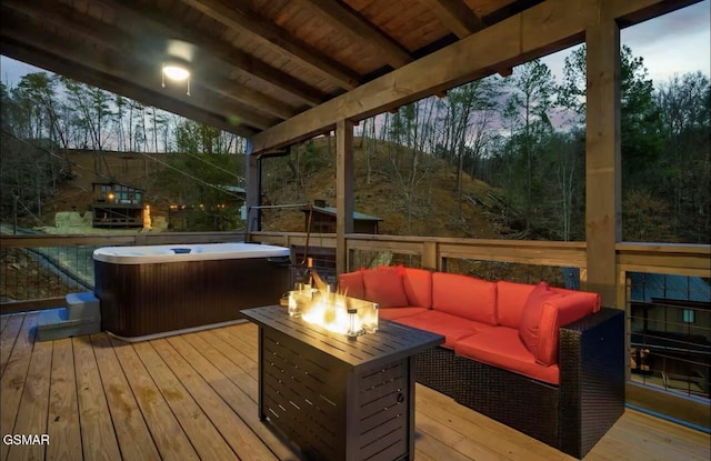 wooden deck featuring a hot tub and an outdoor living space with a fire pit