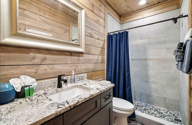 full bathroom featuring wooden walls, toilet, vanity, a stall shower, and wood ceiling