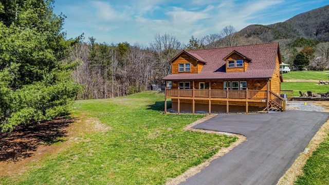 log home featuring a mountain view, a garage, and a front yard