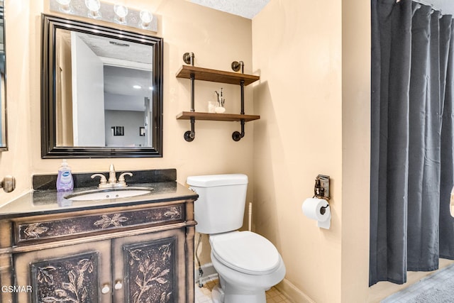 bathroom featuring a textured ceiling, vanity, and toilet