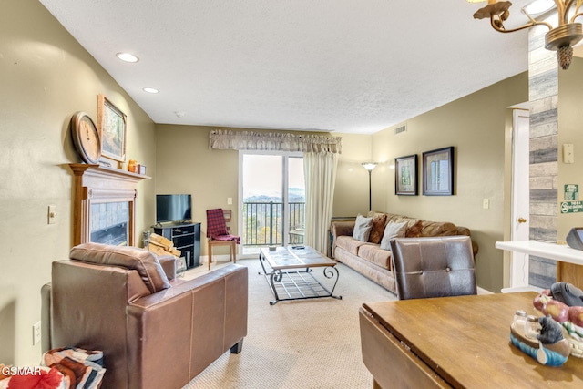 carpeted living room featuring a textured ceiling and a fireplace