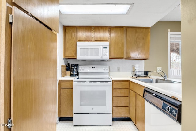 kitchen featuring white appliances and sink