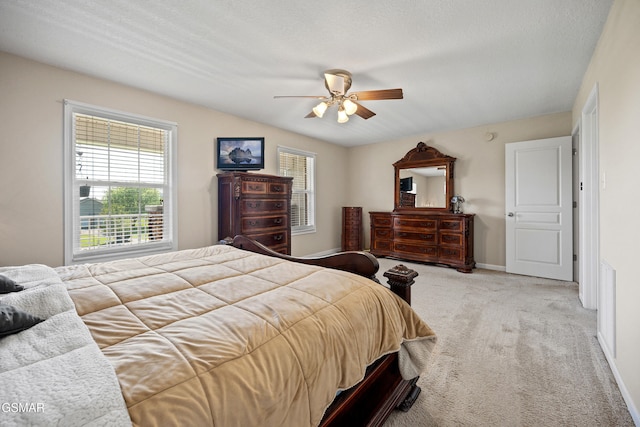 bedroom with light colored carpet, a ceiling fan, and baseboards