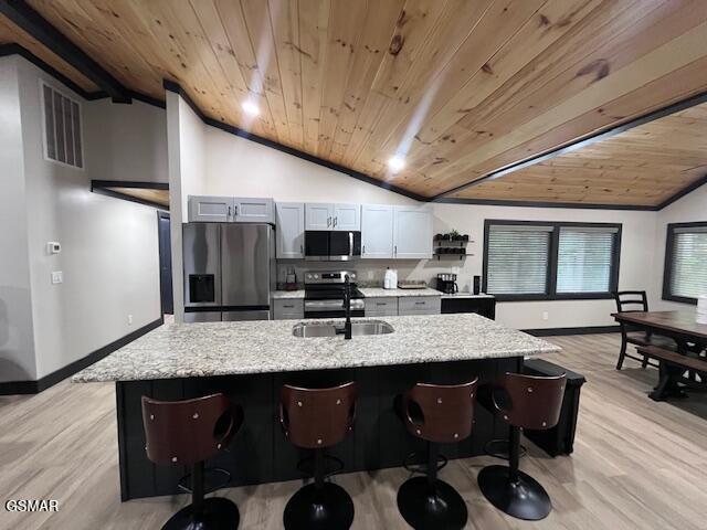 2359 Grassy Branch Rd, Sevierville, TN 37876 - kitchen featuring appliances with stainless steel finishes, vaulted ceiling, wooden ceiling, light wood-type flooring, and a kitchen bar