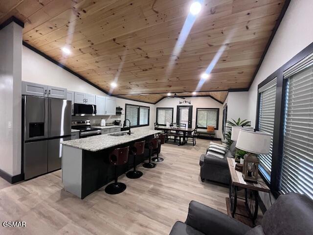 2359 Grassy Branch Rd, Sevierville, TN 37876 - kitchen featuring stainless steel appliances, lofted ceiling, wooden ceiling, light wood-type flooring, and a breakfast bar area