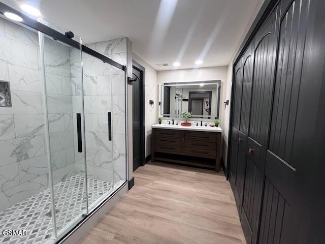 2359 Grassy Branch Rd, Sevierville, TN 37876 - full bath with double vanity, a marble finish shower, wood finished floors, and recessed lighting