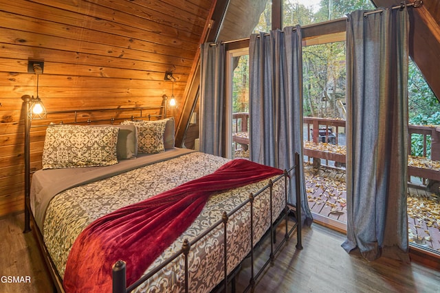 bedroom featuring lofted ceiling, dark hardwood / wood-style floors, wooden ceiling, and wooden walls