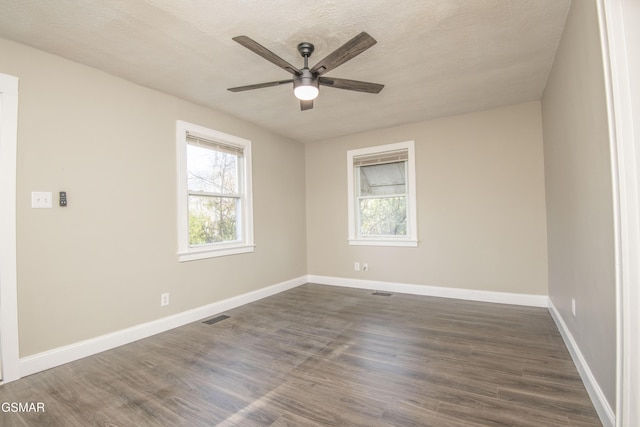empty room featuring baseboards, visible vents, ceiling fan, and a healthy amount of sunlight