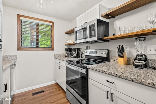 1452 N Arbon Ln, Gatlinburg, TN 37738 - kitchen featuring open shelves, stainless steel appliances, light wood-style flooring, baseboards, and white cabinetry