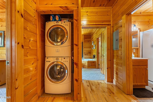 655 Stockton Dr, Sevierville, TN 37876 - laundry area featuring estacked washer and dryer, wood walls, and light wood-type flooring
