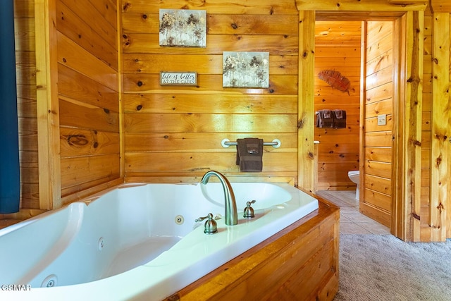 655 Stockton Dr, Sevierville, TN 37876 - bathroom featuring toilet, a whirlpool tub, and wooden walls