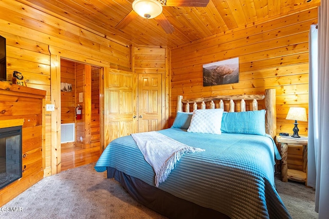 655 Stockton Dr, Sevierville, TN 37876 - bedroom with wood walls, a closet, carpet flooring, wooden ceiling, and a fireplace
