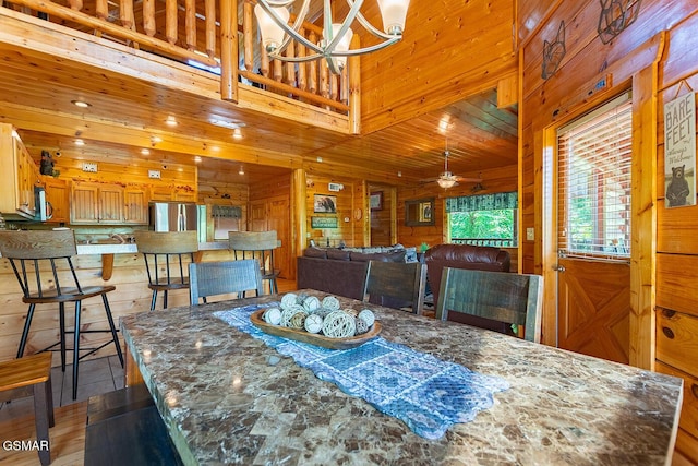 655 Stockton Dr, Sevierville, TN 37876 - dining space with a chandelier, wooden walls, ceiling fan, and wood finished floors