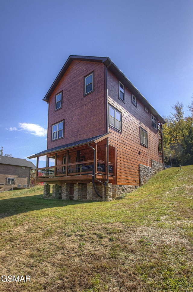 rear view of property featuring a yard and a wooden deck