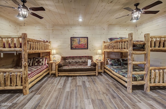 bedroom featuring wood walls, ceiling fan, wooden ceiling, and hardwood / wood-style flooring