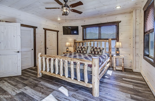 bedroom featuring wood ceiling, ceiling fan, dark wood-type flooring, and wood walls