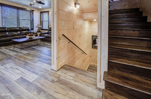 stairs featuring wood walls and wood-type flooring