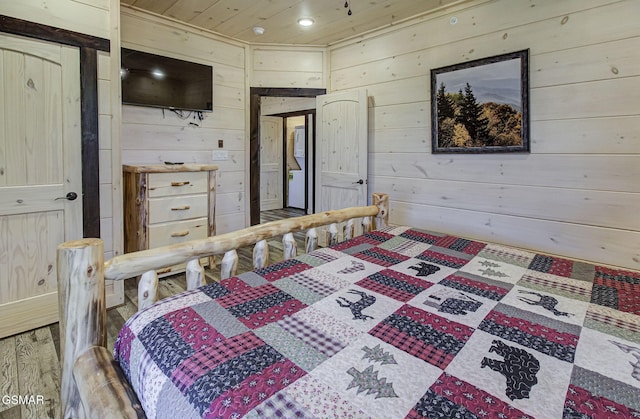 bedroom featuring hardwood / wood-style flooring, wooden ceiling, and wood walls