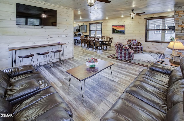 living room with wood ceiling, ceiling fan, light hardwood / wood-style floors, and wood walls