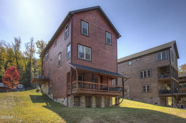 rear view of property with a lawn and a balcony