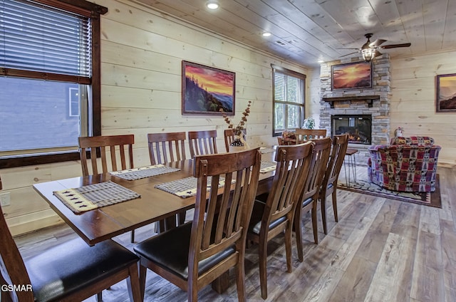 dining room with hardwood / wood-style floors, wooden walls, a fireplace, and wood ceiling