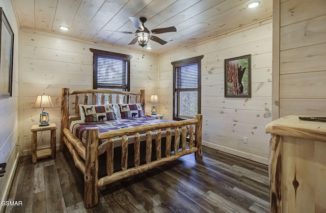 bedroom with ceiling fan, wood ceiling, dark wood-type flooring, and wooden walls