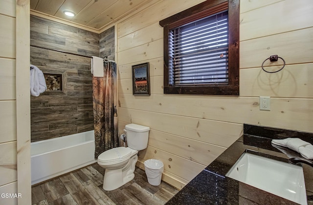 full bathroom featuring hardwood / wood-style floors, shower / bath combination with curtain, sink, wooden walls, and toilet